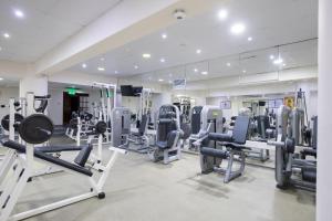 a gym with tread machines and a mirror at Golden Bay Beach Hotel in Larnaca