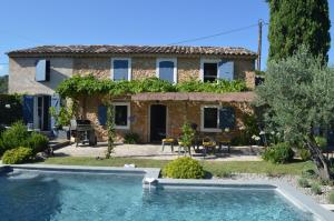uma casa com uma piscina em frente em Le Majalou em Villecroze