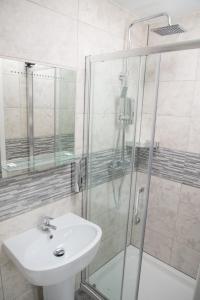 a bathroom with a sink and a shower at TLK Apartments & Hotel - Beckenham High Street in Beckenham