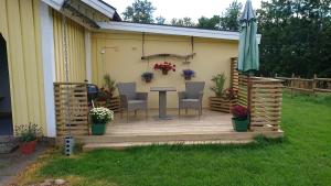 a wooden deck with a table and chairs and an umbrella at Borängs Gård in Ullared