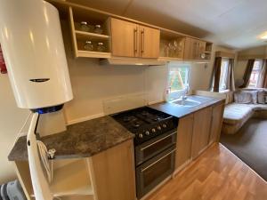 een keuken met een fornuis en een spoelbak bij Mobilný domček in Terchová