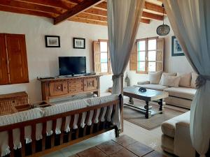 a living room with a couch and a tv at Eco Finca Verde in Arrieta