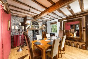 a dining room with a wooden table and chairs at Self Catering Accommodation, Cornerstones, 16th Century Luxury House overlooking the River in Llangollen