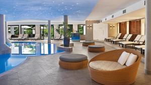 eine Lobby mit Swimmingpool, Liegestühlen und Sitzgelegenheiten in der Unterkunft Hotel Sonnengut Wellness - Therme - Spa in Bad Birnbach