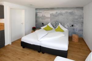 een slaapkamer met een groot wit bed met gele kussens bij Apartments Ante Portas in Salzburg