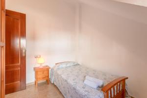 a small bedroom with a bed and a night stand at Apartamento Valle de Abdalajis in Málaga