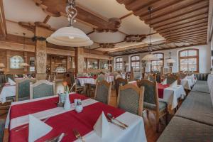 a dining room with tables and chairs and wooden ceilings at Weßner Hof Landhotel & Restaurant in Marquartstein