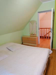 - une chambre avec un lit blanc et un escalier dans l'établissement Domek letniskowy OSP, à Ogonki