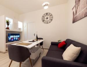 a living room with a couch and a table and a clock at ***La Pétillante*** à 2 pas de la Gare et du Centre ville in Reims