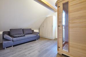 a living room with a blue couch and a mirror at Exklusive Ferienwohnung auf dem Romanshof - Naturidylle pur - Nebengebäude in Loßburg