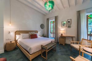 a bedroom with a bed and a chair and windows at Nou Baleares in Palma de Mallorca