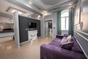 - un salon avec un canapé violet et une cheminée dans l'établissement Krepost Mini Hotel, à Makhachkala