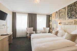 a hotel room with two beds and a tv at Parkhotel Bilm im Glück am Stadtrand Hannovers in Sehnde