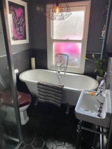 een badkamer met een bad, een wastafel en een raam bij Luxury 2 bedroom flat heart of Camden in Londen