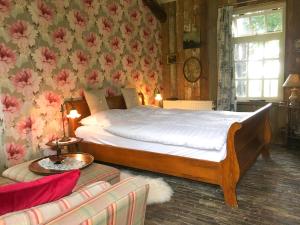 een slaapkamer met een groot bed met bloemen aan de muur bij Vakantiehuizen Kats Zeeland De Zwaluwenhof in Kats