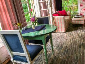 a green table and chairs in a living room at Vakantiehuizen Kats Zeeland De Zwaluwenhof in Kats