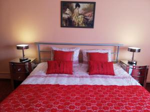 sypialnia z czerwonym łóżkiem i 2 czerwonymi poduszkami w obiekcie Luxury Brasov w Braszowie