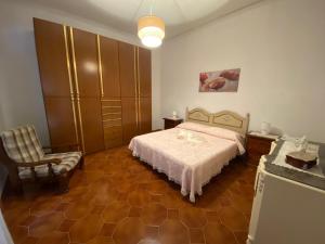 a bedroom with a bed and a chair at La Casetta di Nonna Anna in Palermo