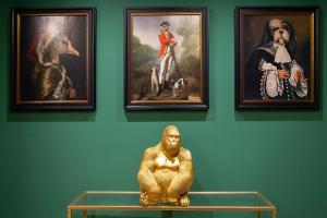 três quadros emoldurados numa parede com uma estátua numa prateleira em Hotel Paba em Roma