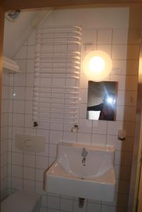 a person taking a picture of a bathroom with a sink at Hotel Senfkorn in Eldagsen