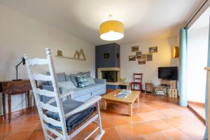 uma sala de estar com uma escada, um sofá e uma mesa em La Bergerie apartment in an old farmhouse! em Nâves-Parmelan