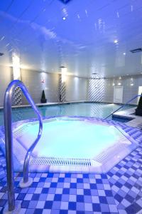 a large swimming pool with a hand rail in a building at Burnley North Oaks Hotel and Leisure Club in Burnley