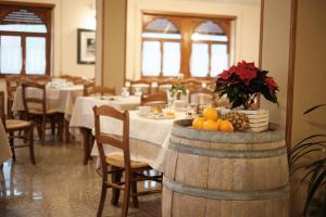 een eetkamer met een tafel met sinaasappels op een vat bij Albergo Trattoria Speranza in Foza