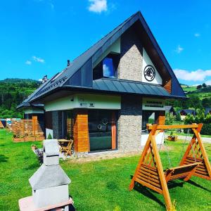 a house with a clock on the side of it at DOMKI TU I TERAZ in Szczawnica