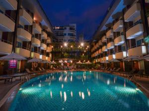 a swimming pool in a hotel at night at Baron Beach Hotel in Pattaya