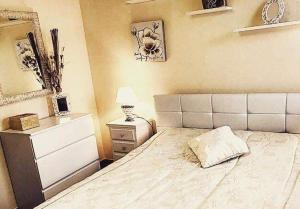 una camera con letto, cassettiera e lampada di Casa vacanze valledoria a Valledoria