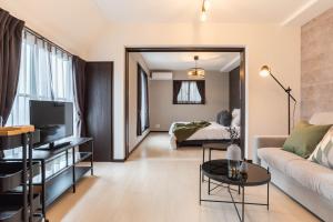 a living room with a couch and a bed at Bijou Suites Vivre in Osaka