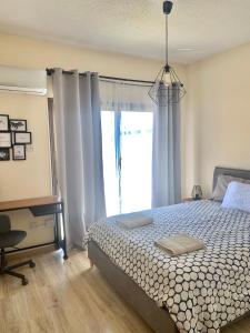 een slaapkamer met een bed, een raam en een bureau bij Evitas House in Paphos City