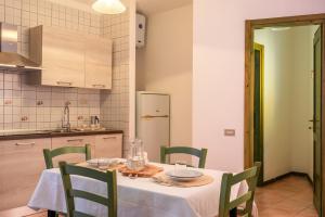 a kitchen with a table with a white table cloth and chairs at Residence Le Pavoncelle in Santa Teresa Gallura