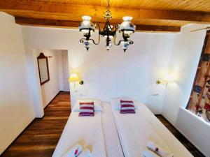 a large white bed in a room with a chandelier at Vila Eivissa in Porumbacu de Sus