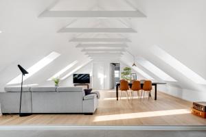a living room with a white ceiling and a couch and chairs at aday - Penthouse 3 bedroom - Heart of Aalborg in Aalborg