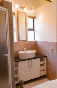 a bathroom with a sink and a mirror at Rest-a-While Guest House - Pretoria in Pretoria
