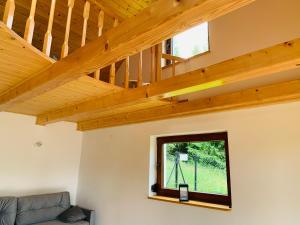 a living room with wooden ceilings and a window at FlowMove Retreat Kamesznica in Kamesznica