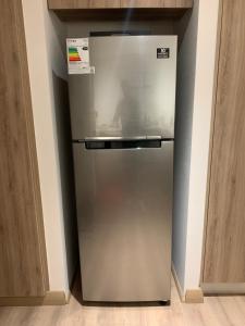 a stainless steel refrigerator in the corner of a kitchen at Terrazas de Cochoa in Viña del Mar