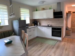 a kitchen with white cabinets and a table and a refrigerator at Ferienhaus Feil in Oberdrauburg