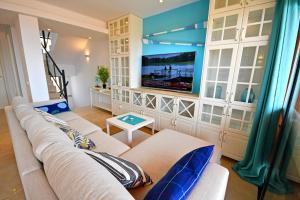 a living room with a couch and a flat screen tv at Panorama Blue in Caleta De Fuste