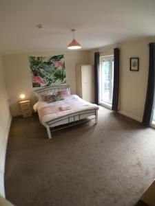 ein Schlafzimmer mit einem Bett und einem großen Fenster in der Unterkunft 4 Bedrooms, 3 Bathrooms, Comfy beds, 5 Netflix TVs & VAN PARKING in Boston