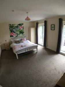 ein Schlafzimmer mit einem Bett und zwei Fenstern in der Unterkunft 4 Bedrooms, 3 Bathrooms, Comfy beds, 5 Netflix TVs & VAN PARKING in Boston + 8 Fotos