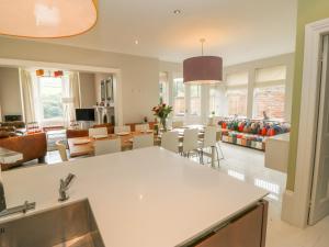 a kitchen and living room with a table and chairs at Ash Villa in Holmfirth