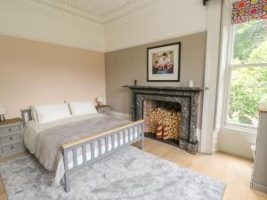 a bedroom with a bed and a fireplace at Ash Villa in Holmfirth