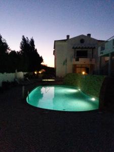 - une piscine en face d'une maison la nuit dans l'établissement Casa Carmela, à Burgau