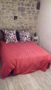 Un dormitorio con una cama roja con almohadas. en Le vitrail CHAMBRE Équipée sans service repas, en Yvetot Bocage