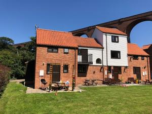 a large brick building with a house on the side at Captain Cook Riverside Walk in Whitby
