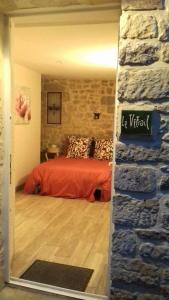 a bedroom with a bed and a brick wall at Le vitrail CHAMBRE Équipée sans service repas in Yvetot Bocage