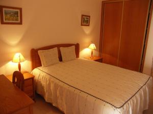 a bedroom with a bed and two lamps on tables at Clube Meia Praia in Lagos