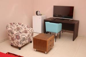 a room with a desk and a chair and a television at WELCOME LODGE in Ouagadougou +10 photos